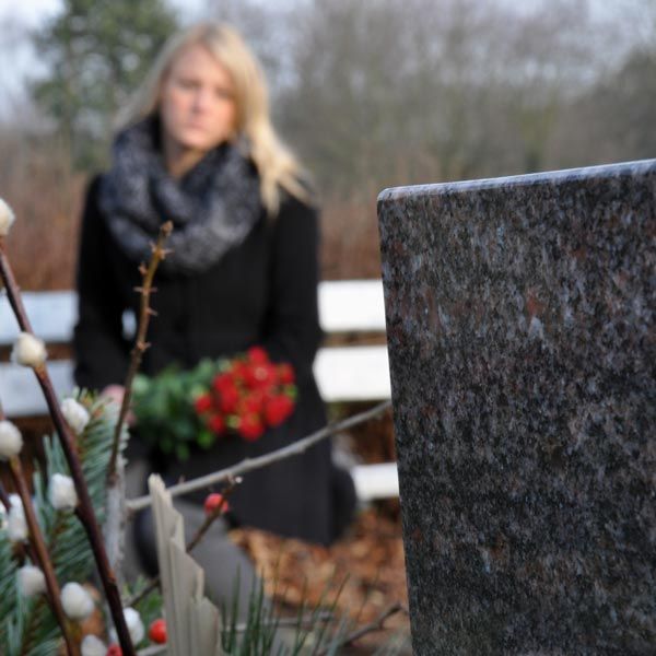 Woman in black next to grave